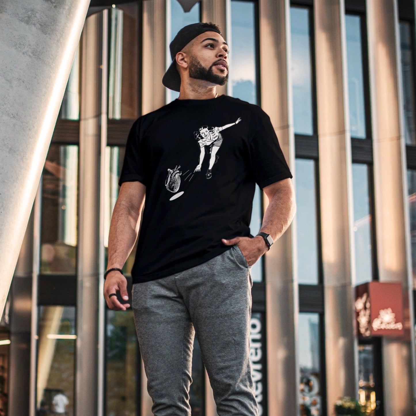 Man wearing a t-shirt depicting a woman bowling with a human heart