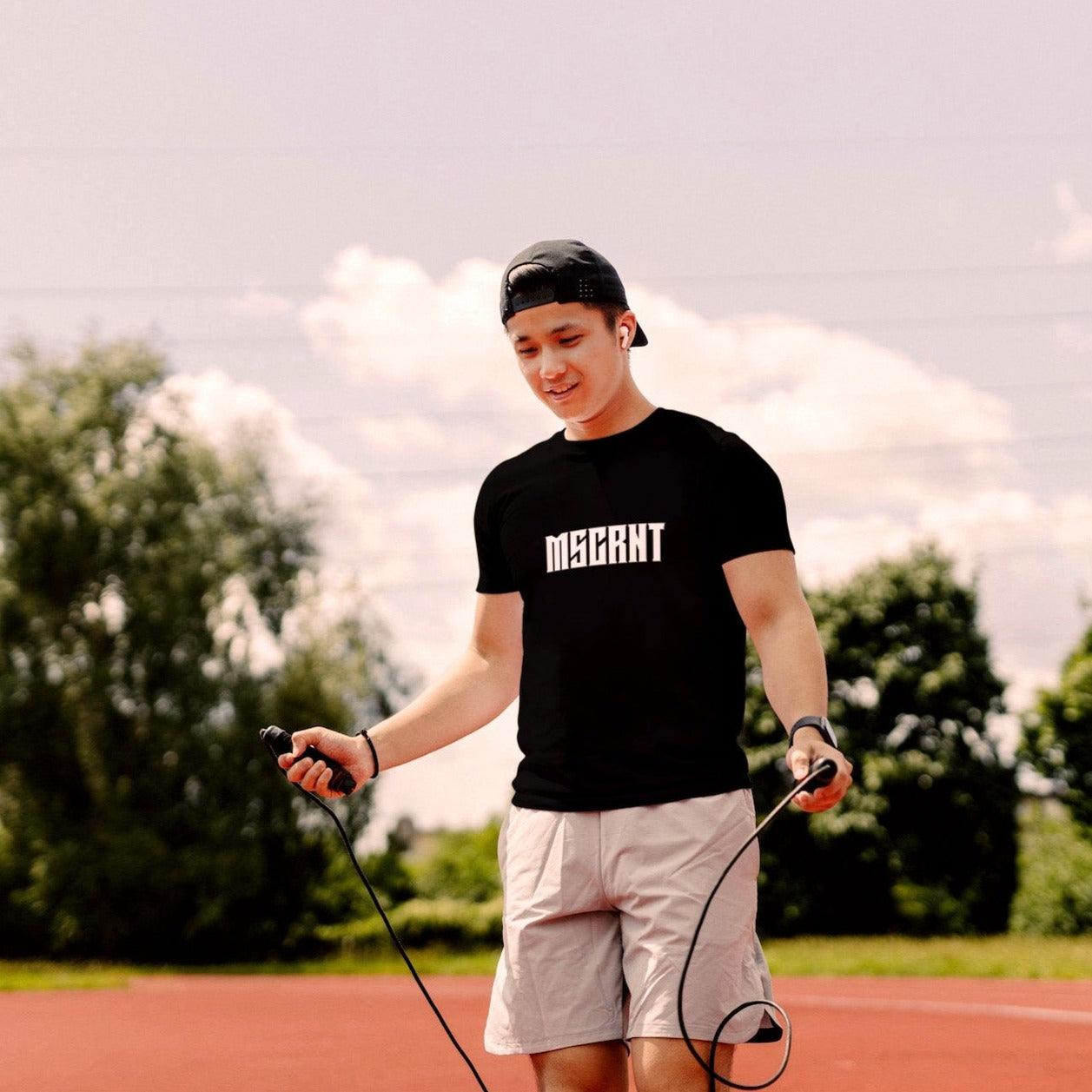 Man wearing a blackt t-shirt with the MSCRNT logo in white